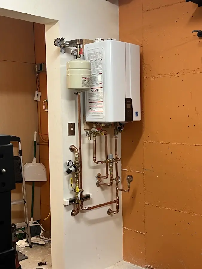 Plumbing technician inspecting water heater connections in Braselton